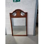 A contemporary wall mirror with 'ironwork' detail to top.