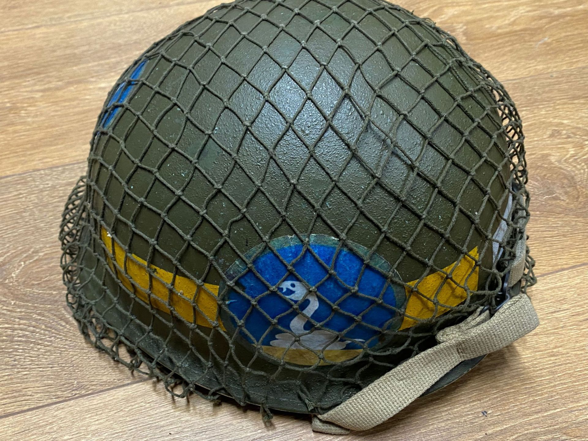 A US M1 military police helmet with a Vietnam era liner, modern decals, with netting and chin strap. - Image 4 of 5
