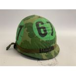 A US M1 airborne training helmet with embroidered band bearing the name Davidson. The cover with