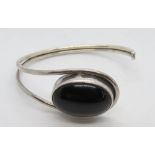 A silver and black onyx cabachon bangle, stamped 925.