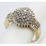 A 9ct gold diamond cocktail ring having large central cluster and encrusted shoulders,