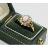 A 9ct gold opal cluster ring, the central opal cabachon surrounded by a gallery of white stones,