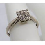 A 9ct white gold and diamond ring, the nine round cut stones set in a square head totalling 0.