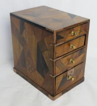 An apprentice type tabletop chest of drawers having various inlay and marquetry designs throughout.