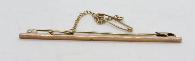 A vintage 9ct rose gold bar brooch having safety chain and catch upon, 2.4g.