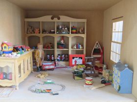A two storey dolls house opening to reveal a toy shop with vast array of toys within,