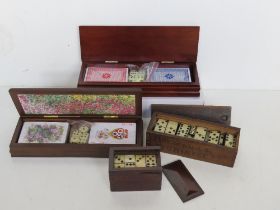 Two contemporary bridge playing cards boxes together with two vintage sets of dominoes.