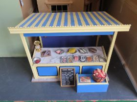 A dolls house fishmongers market stall with sign and wares.
