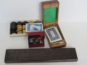 A quantity of gaming items including cribbage boards, playing cards, draught pieces, etc.