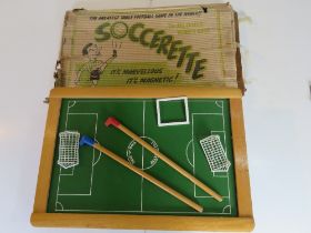 A mid century Soccerette table football game with box in play worn condition.