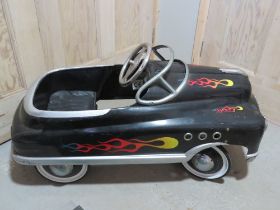 A pedal car modelled as a 1950's Black Hot-Rod Comet.