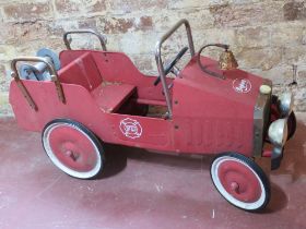 A pedal car in the form of a fire engine having bell to bonnet. Measuring approx 94cm in length.