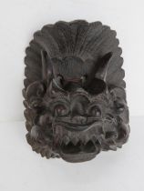 A carved Oriental hard wood mask of a Chimera approx 18cm high.