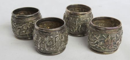 Four associated white metal napkin rings.