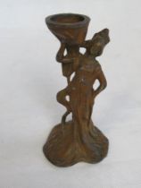 An Art Nouveau cast metal candle stand in the form of a classical female.