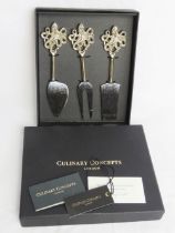 A set of as new in box Culinary Concepts cheese knives in octopus pattern.