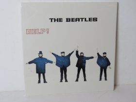 A contemporary 'The Beatles Help!' record themed decorative ceramic plaque.