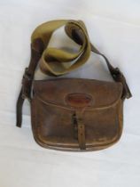 A leather cartridge bag with canvas strap.