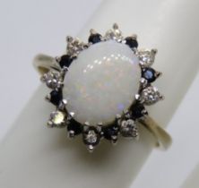 A 9ct gold opal cocktail ring having sapphire and white stone border,