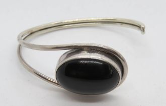 A silver and black onyx cabachon bangle, stamped 925.