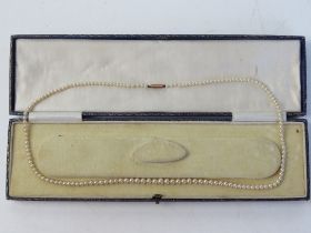 A vintage single strand faux pearl necklace having 9ct gold clasp in associated box.