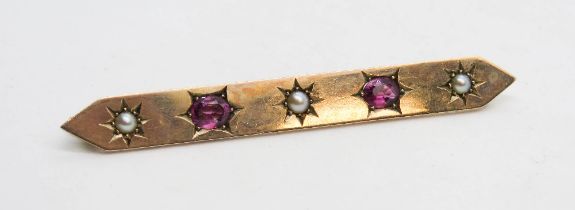 An Edwardian 9ct gold bar brooch having seed pearls and pink stones upon, 6.5cm, 6.4g.