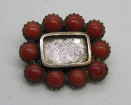 A Georgian brooch having central glazed panel surrounded by coral half beads, 2 x 1.8cm, 3.1g.