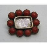 A Georgian brooch having central glazed panel surrounded by coral half beads, 2 x 1.8cm, 3.1g.