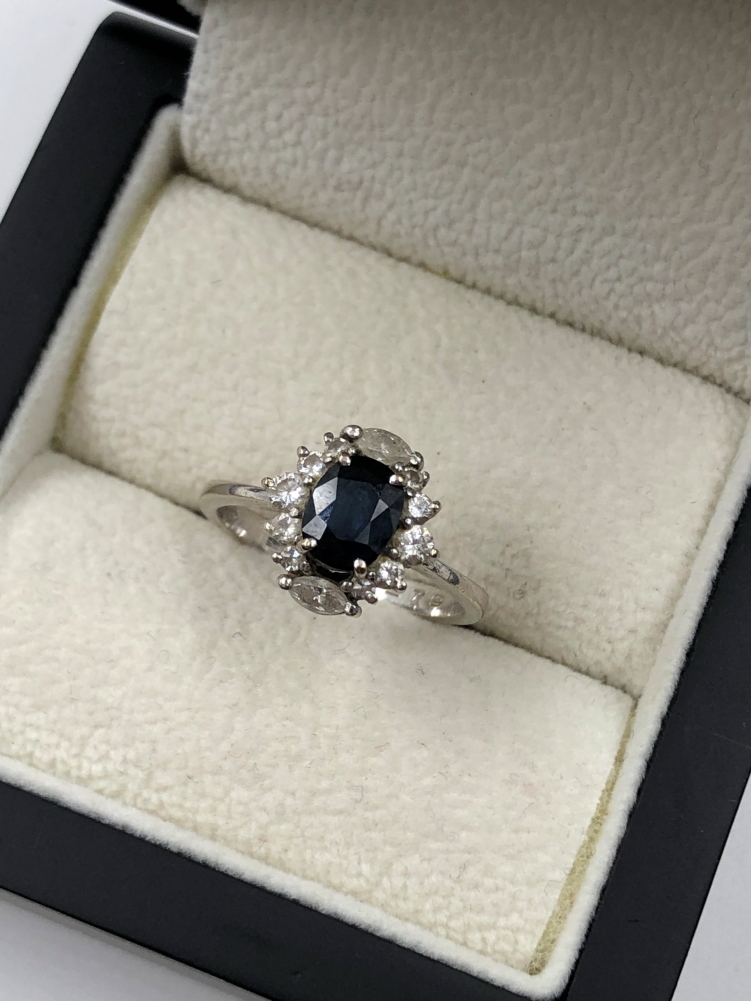 A SAPPHIRE AND DIAMOND CLUSTER RING. THE OVAL SAPPHIRE IN A FOUR CLAW SETTINGS, SURROUNDED BY TWO - Image 5 of 7