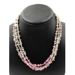 A THREE ROW STRAND OF CULTURED FRESHWATER PEARLS WITH AN OMBRE PINK AND GREY HUE. COMPLETE WITH A