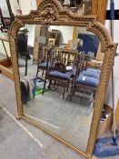 A 19th C. GILT FRAMED MIRROR CRESTED BY A RIBBON, THE SIDES WITH AN EGG AND DART BAND IN RELIEF. 144