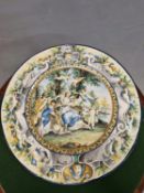 A 19th C. FAENZA DISH PAINTED WITH A LADY SEATED ON A RECLINING BULL WITH HER ATTENDANTS AND