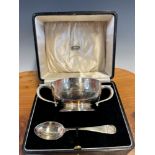 A CASED SILVER TWO HANDLED CHRISTENING BOWL AND SPOON BY ATKINSON BROTHERS, BIRMINGHAM 1935, THE RIM