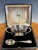 A CASED SILVER TWO HANDLED CHRISTENING BOWL AND SPOON BY ATKINSON BROTHERS, BIRMINGHAM 1935, THE RIM