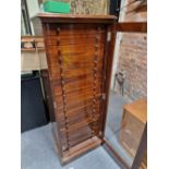 A MAHOGANY COLLECTORS CHEST WITH A GLAZED DOOR ENCLOSING TWENTY DRAWERS ABOVE A PLINTH FOOT. W 56