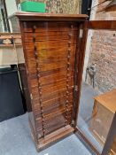 A MAHOGANY COLLECTORS CHEST WITH A GLAZED DOOR ENCLOSING TWENTY DRAWERS ABOVE A PLINTH FOOT. W 56