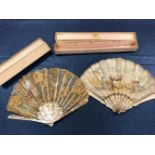 TWO BOXED FANS, THE MOTHER OF PEARL STICKS CARVED AS FEATHERS, ONE LEAF PAINTED WITH A LADY