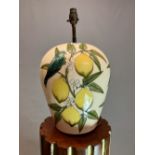 A MOORCROFT OVOID TABLE LAMP SLIP TRAILED WITH BLUE BIRDS ON LEMON BRANCHES AGAINST A CREAM