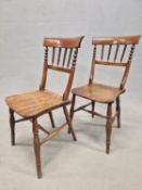 A PAIR OF OAK COUNTRY CHAIRS, THE BROAD TOP RAILS OVER RING TURNED SPINDLES, THE SADDLE SEATS ON