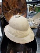 A GEORGE WINTER PITH HELMET IN A TIN CASE WITH A BRASS LABEL FOR GENERAL SIR CHARLES MONRO (1860-