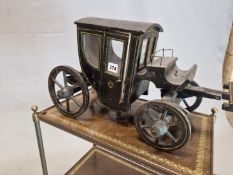A WOODEN MODEL HACKNEY CARRIAGE PAINTED IN BLACK WITH DETAILS IN YELLOW LINES, THE FOUR WHEEL