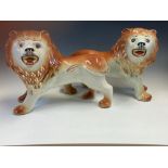 A PAIR OF SADLERS POTTERY LIONS STANDING FOUR SQUARE AND ROARING. W 37cms.