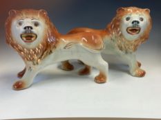 A PAIR OF SADLERS POTTERY LIONS STANDING FOUR SQUARE AND ROARING. W 37cms.