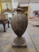 A WOOD FINIAL, THE BALUSTER SHAPE CARVED WITH SPIRAL RIBBING ABOVE A SLENDER SOCLE AND THE SQUARE