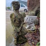 AN OLD WEATHERED GARDEN FIGURE OF PAN SEATED. TOGETHER WITH A CURVED GARDEN SEAT ON LION SUPPORTS