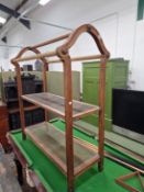 A PINE LINEN STAND, THE THREE TOP RAILS SUPPORTED BY ARCHED ENDS ABOVE TWO CANE WORK SHELVES. W
