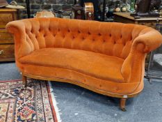 AN EDWARDIAN MAHOGANY BUTTON BACKED TWO SEAT SETTEE UPHOLSTERED IN ORANGE VELVET, THE FLUTED CYLINDR