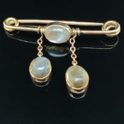 A VINTAGE MOONSTONE BAR BROOCH. THE THREE OVAL CABOCHON MOONSTONES IN RUBOVER STYLE SETTINGS.