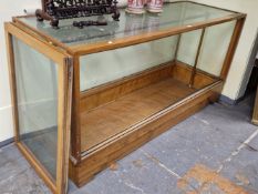 A 20th C. GLAZED OAK HABERDASHERS DISPLAY COUNTER, THE RECTANGULAR TOP, SIDES AND FRONT GLAZED AND