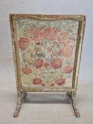 A GILT WOOD FIRESCREEN WITH THE NEEDLE WORK PANEL WORKED WITH RED CARNATIONS. 92 x 64cms.